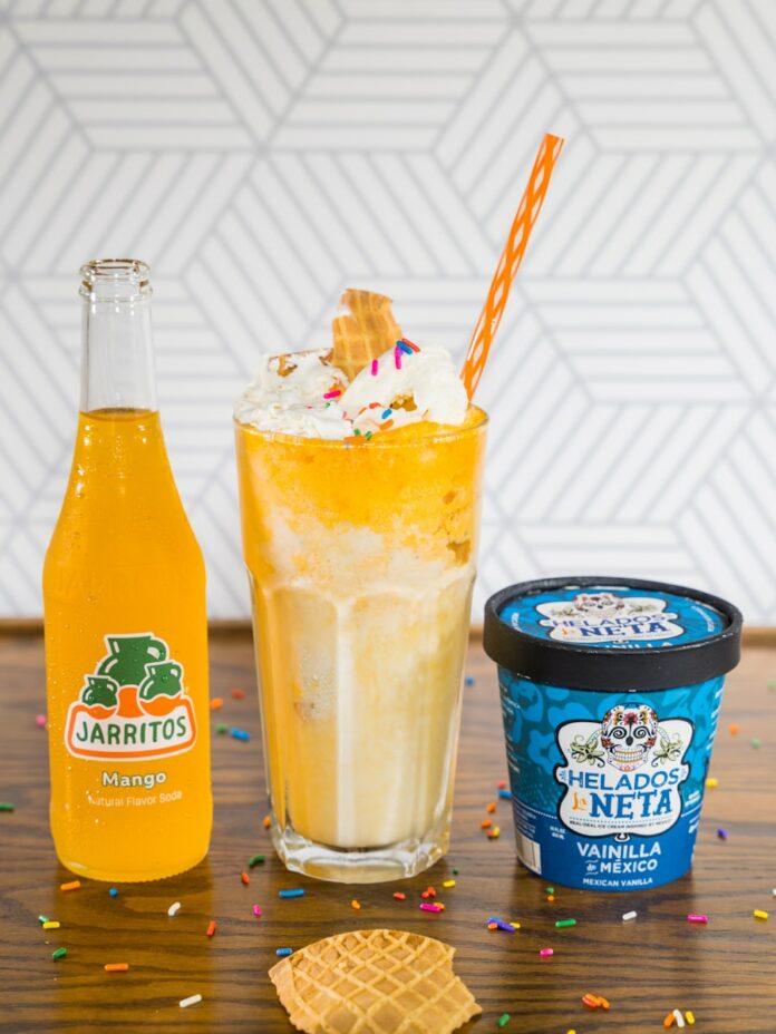 Photo by Jarritos Mexican Soda orange juice in clear drinking glass