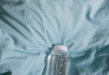 여름의 끝자락, 똑똑한 수면 관리로 더위 극복하기 clear plastic bottle on blue textile