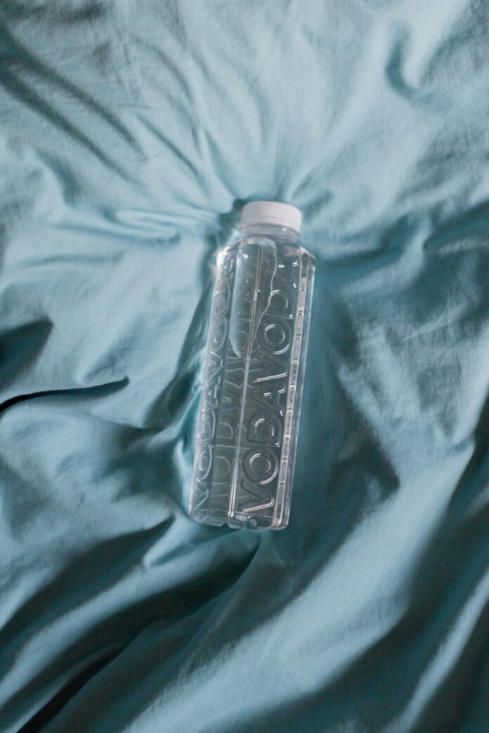 Photo by Filip Baotić clear plastic bottle on blue textile