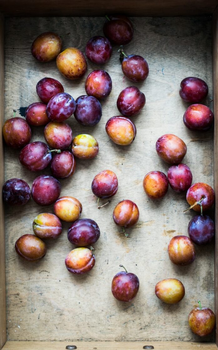 Photo by Monika Grabkowska bunch of Spanish plum on brown surface