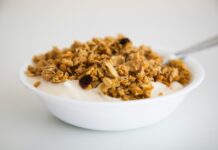 체중 감량에 도움이 되는 아침 운동과 식단 구성 a bowl of granola and yogurt with a spoon