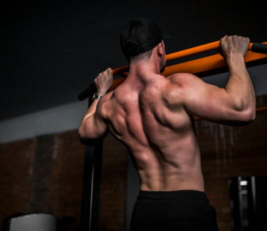 운동 후 근육통, 그냥 참아야 할까? topless man in black shorts holding orange bar