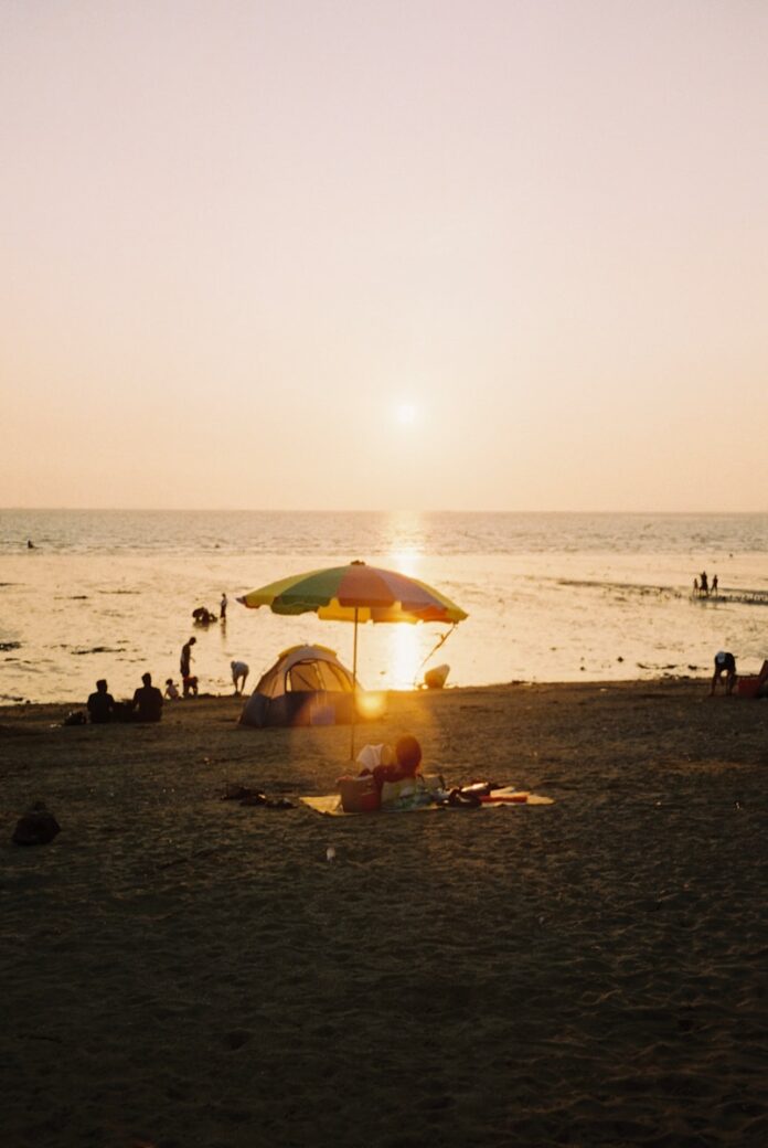 Photo by allrosees a beach with people and umbrellas
