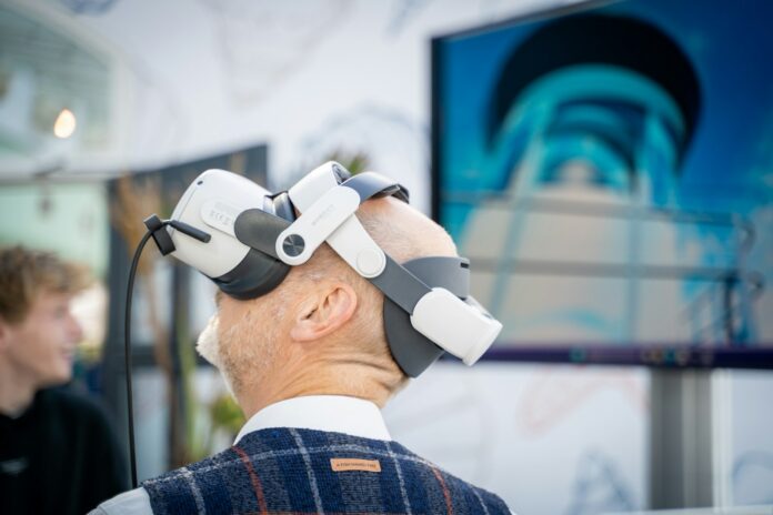 Photo by Paul Einerhand A man wearing a robot headpiece in front of a TV