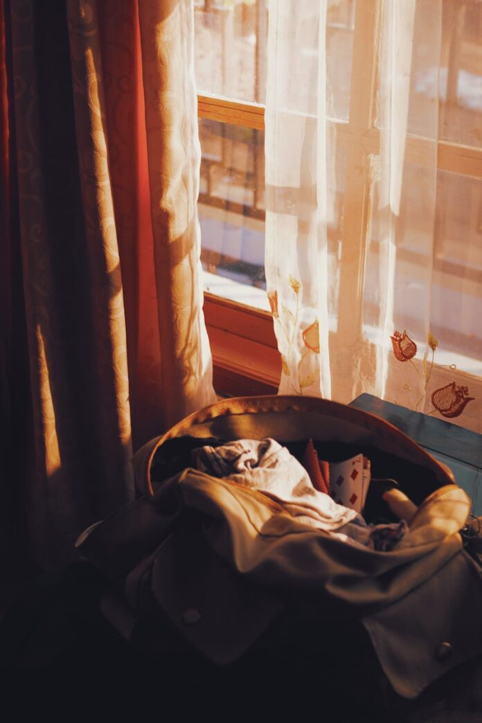 Photo by Firas Wardhana Sunlight streams through a window onto a basket of clothes.