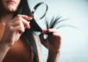 머릿결도 건강해야 아름답다…일상 속 실천하는 ‘두피·모발 관리법’ 주목 Woman examining split ends of hair with magnifying glass