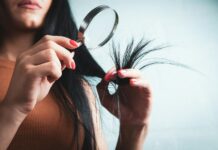 머릿결도 건강해야 아름답다…일상 속 실천하는 ‘두피·모발 관리법’ 주목 Woman examining split ends of hair with magnifying glass