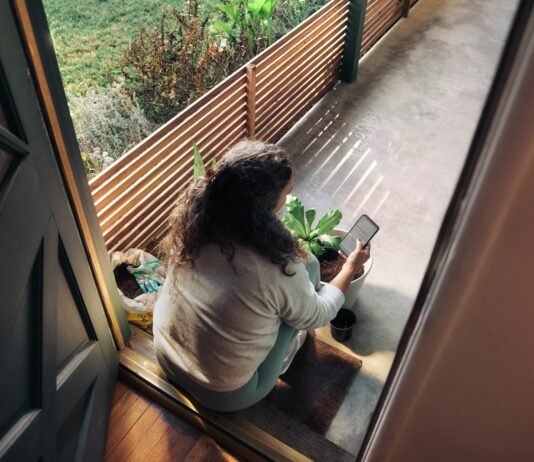 만성피로, 내 생활을 바꾸는 작은 루틴이 답이다 Woman sitting on balcony with smartphone
