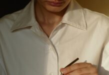 한국인의 일상에 스며드는 웰니스 문화, 건강을 일상에서 찾다 person in white button up shirt holding clear drinking glass with green liquid