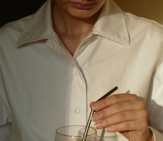 한국인의 일상에 스며드는 웰니스 문화, 건강을 일상에서 찾다 person in white button up shirt holding clear drinking glass with green liquid